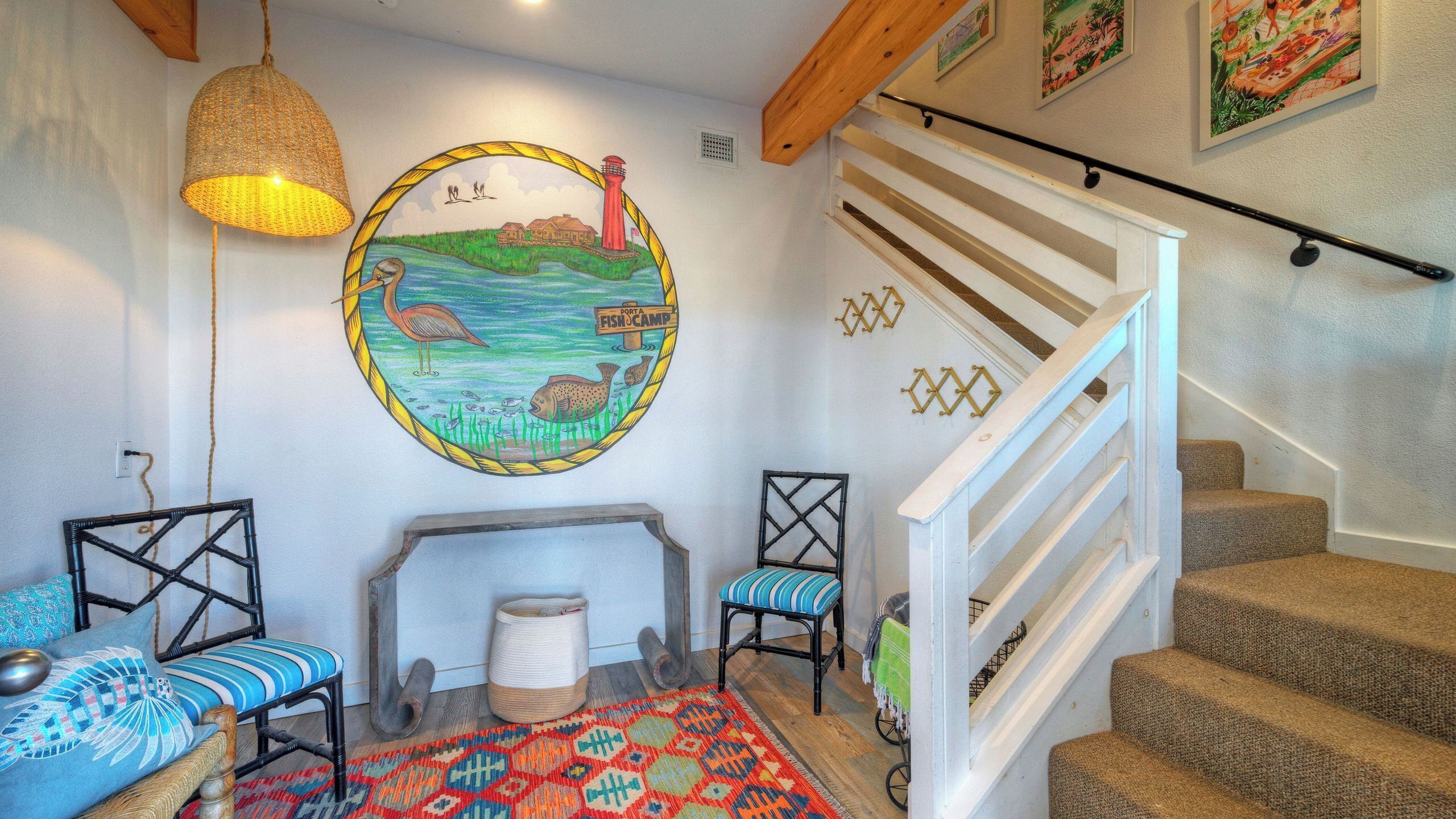 Une pièce chaleureuse avec une cheminée, un tapis coloré et un escalier.