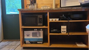 A kitchen with a microwave, coffee maker, and a clock on the wall. - Popeye and Grammy’s Lookout Point: Cozy Lakeside Cabin for Two (Cornell)