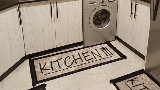 A compact kitchen with a washing machine, a microwave, and a sink.