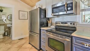 A modern kitchen with stainless steel appliances, including a refrigerator, microwave, and oven. - Charming Home with Hot Tub and Garden, 20 minutes to Beach. (Palmetto)