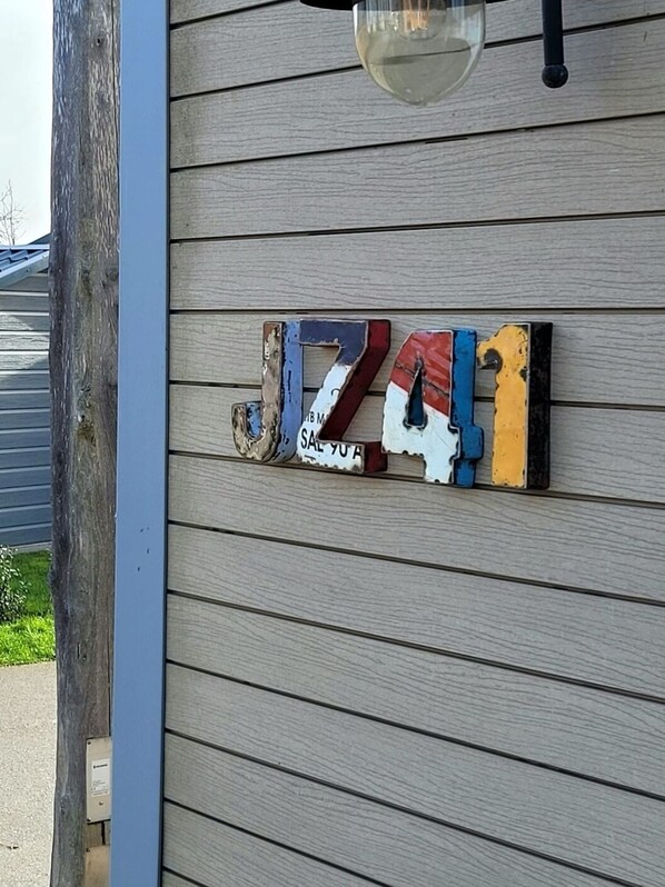 A wooden wall with a decorative sign that reads "JAZZ SALE YOURS". - Vacation park chalet near the beach, modern, cozy and well furnished. (Oostkapelle)