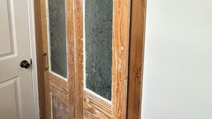 A wooden door with frosted glass panels and a metal handle. - Cozy 1-bedroom apartment in adorable New Orleana with AC (New Orleana)