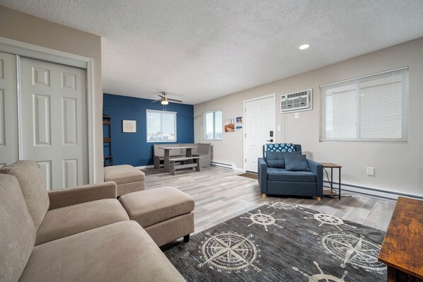 A living room with a beige sofa, a blue sofa, a coffee table, and a rug with a nautical design. - 2-bedroom Condo in OCMD Centrally Located, 2 Parking Spaces, Pool, and Grills (Ocean City)