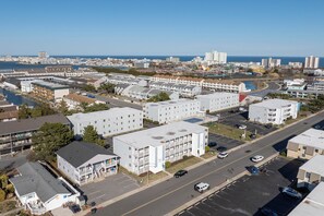A coastal urban area with multi-story buildings, a marina, and a clear view of the sea. - 2-bedroom Condo in OCMD Centrally Located, 2 Parking Spaces, Pool, and Grills (Ocean City)