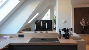 Une cuisine moderne dotée d’un plan de travail en bois, d’appareils électroménagers intégrés et d’une grande fenêtre laissant entrer la lumière naturelle.