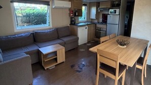 A compact living space with a sofa, a dining table, and a kitchenette. - A splendid place les mathes la Palmyre la rochelle .royan lieux plage dynamic (Les Mathes)