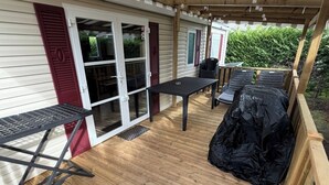 A covered patio with a table and chairs, a grill, and a wooden deck. - A splendid place les mathes la Palmyre la rochelle .royan lieux plage dynamic (Les Mathes)