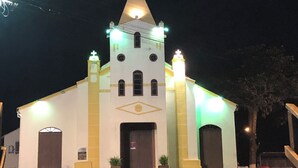 Une église surmontée d’une croix, illuminée par des jeux de lumière, et dotée d’un clocher.