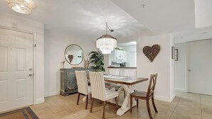 Un coin repas agrémenté d’un lustre, d’un miroir rond et d’une décoration murale en forme de cœur.
