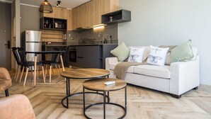 Una cocina moderna con armarios de madera, horno integrado y un comedor con una mesa redonda y sillas.