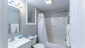 A bathroom with a toilet, sink, and shower.