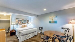 A hotel room with a bed, a desk, a chair, a bathtub, and a painting on the wall.