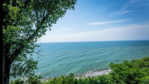A coastal view with clear waters and a rocky shoreline. - Lakefront king studio with queen sofa sleeper  (Whitehall)