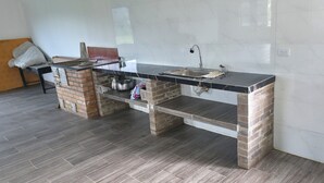 Una cucina con un piano di lavoro in marmo, un lavello e una base in mattoni.