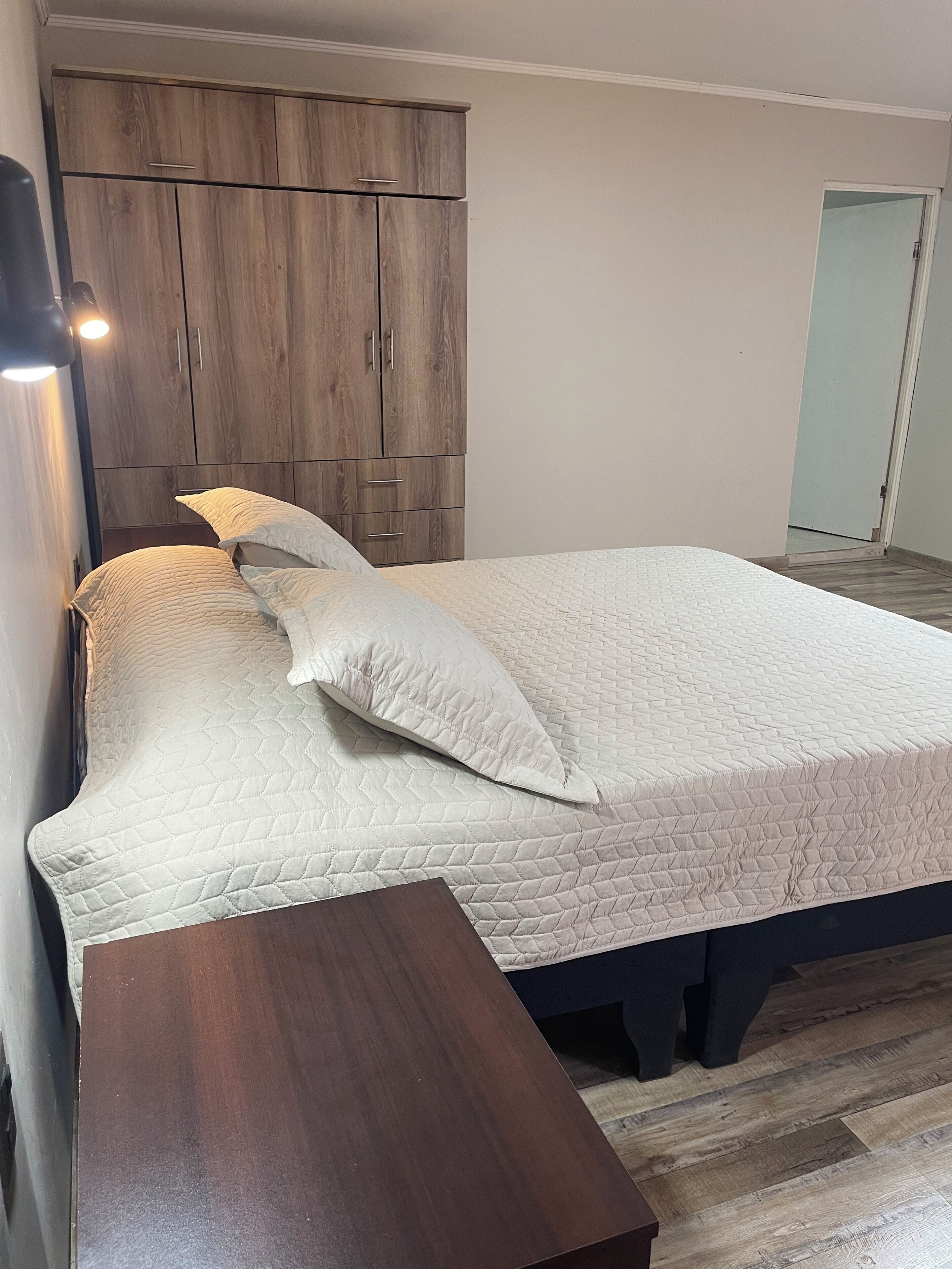Ein Schlafzimmer mit einem Bett, einem Holzschrank und einem Nachttisch.