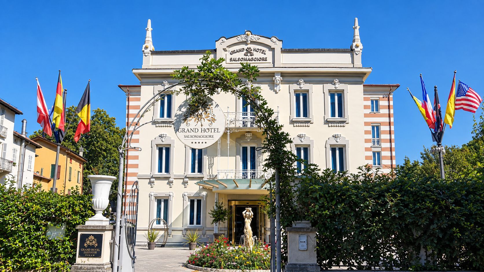 Ein prächtiges Hotel mit klassischer Fassade, mehreren Flaggen und einem zentralen Eingang.