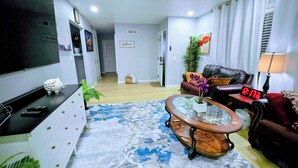 Una sala de estar con televisor, sofá, mesa de centro y un reloj que marca las 12:17.