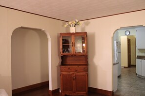 Ein Holzschrank mit Glastüren und einer Blumenvase darauf.