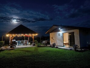 A modern house with a covered outdoor area, a car parked outside, and a well-maintained lawn. - Near the Tenorio volcano and Katira Labyrinth, comfortable villa for 5! (Katira)