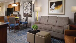 A modern hotel room with a sofa, ottoman, and a dining area with chairs and a table. - Resort with 1 bdrm close to Waste Mngmt. Phoenix Golf Tournament in Scottsdale (Scottsdale)