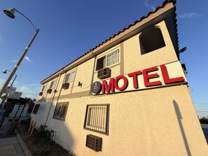 Un bâtiment sur lequel on peut lire l’inscription « Motel » et où est affiché un panneau avec une cloche indiquant « Bell Motel ».