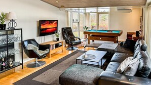 A modern living room with a pool table, leather sofas, a TV, and a glass cabinet. - Pet friendly home in Ebeltoft with WiFi (Ebeltoft)