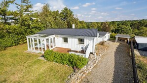 A white house with a glass conservatory, a wooden deck, and a gravel driveway. - Pet friendly home in Ebeltoft with WiFi (Ebeltoft)