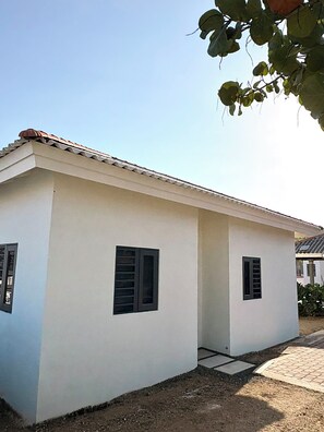 A small, single-story building with a flat roof and two windows with shutters. - Lux Apartment Stay (Willemstad)