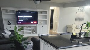 Eine Küche mit einem Barhocker, einem Fernseher und einer Pflanze.