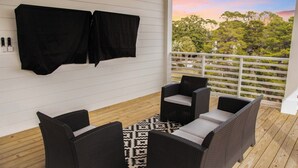 Ein Balkon mit Korbmöbeln und einem gemusterten Teppich.