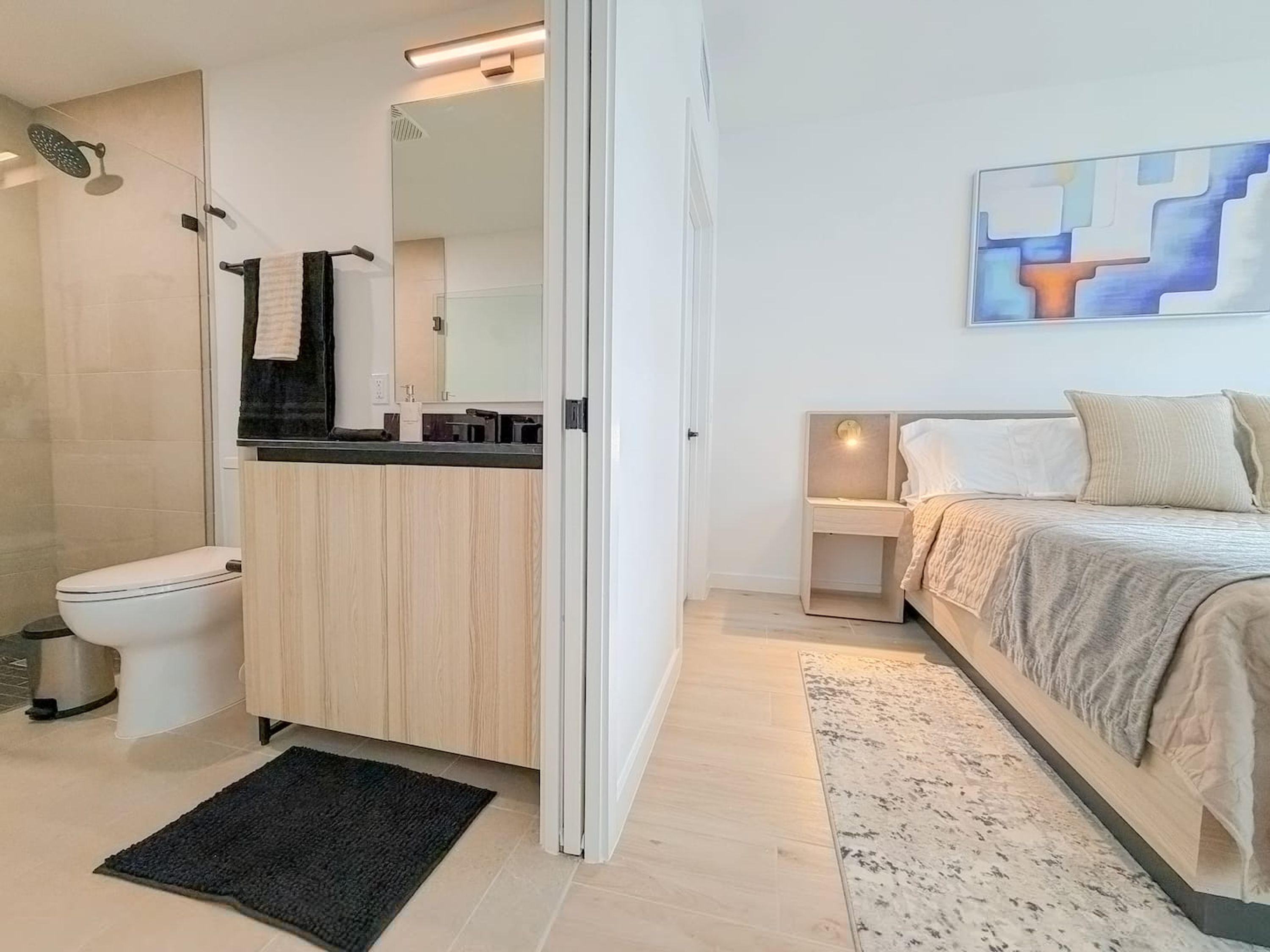 A modern bathroom with a shower, toilet, and sink.