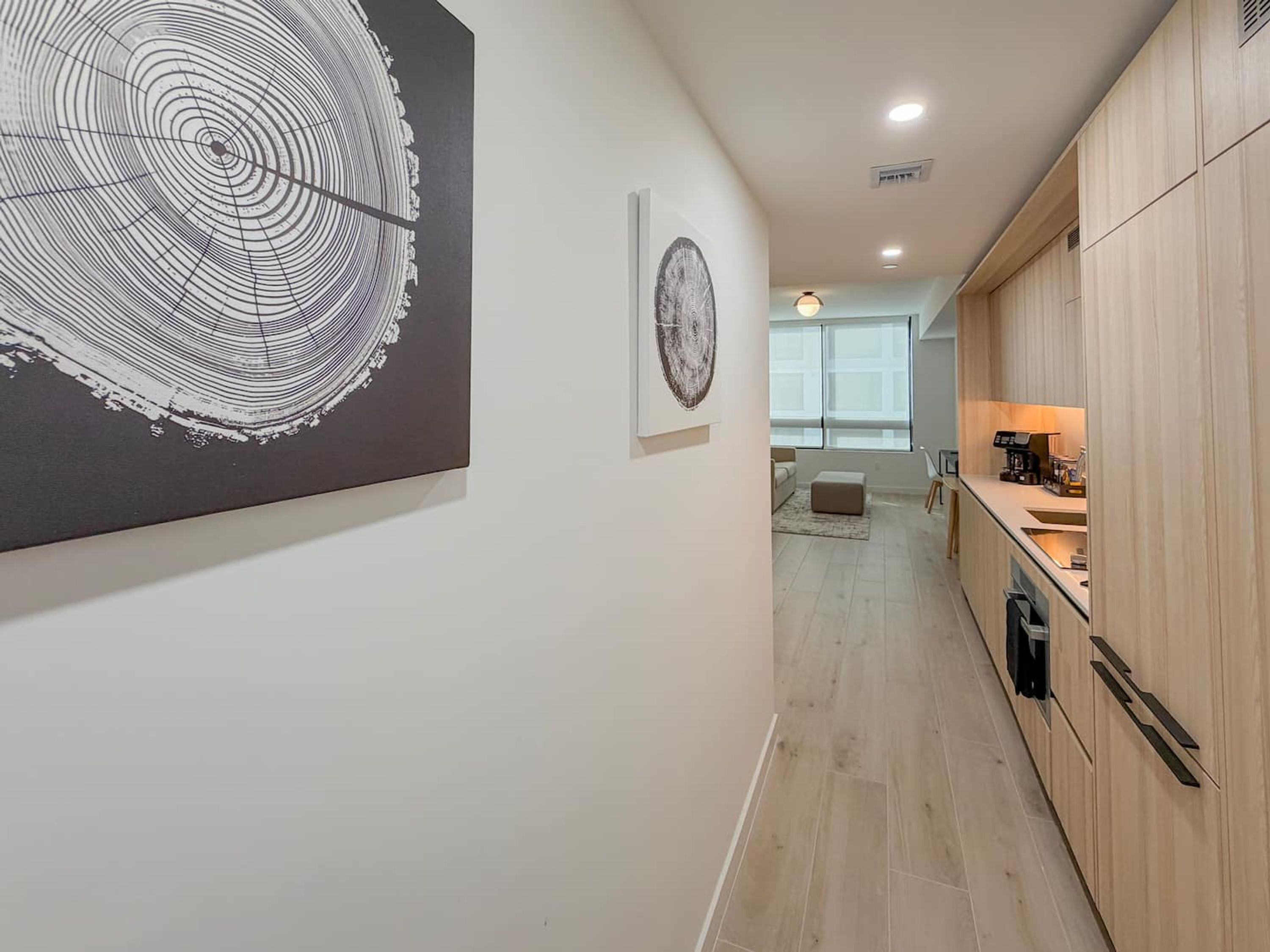 Una cocina moderna con armarios de madera, una encimera y un comedor con una mesa y sillas.