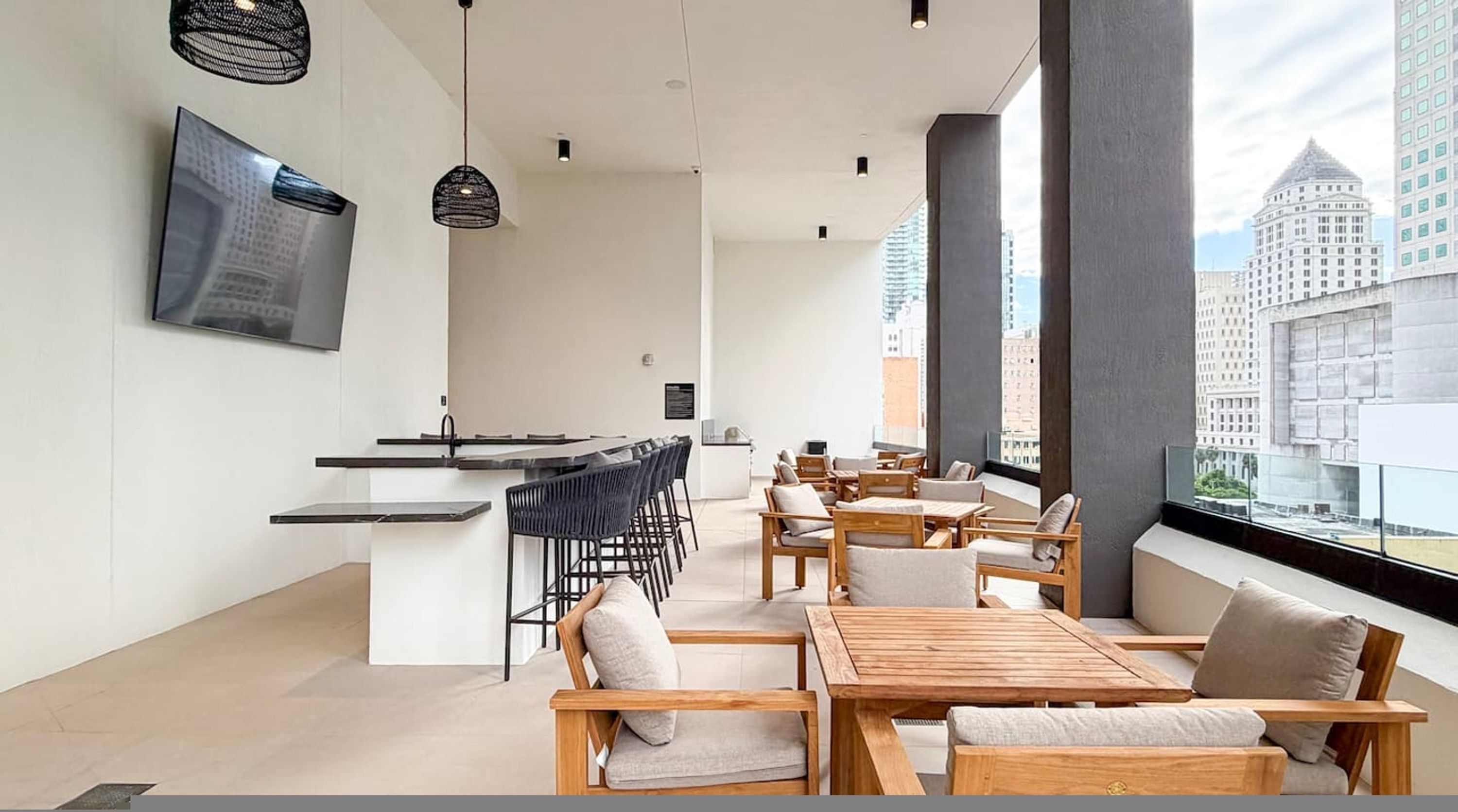 Ein modernes Interieur mit Bar, Sitzgelegenheiten und großen Fenstern mit Blick auf die Stadt.