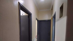 A narrow hallway with a carpeted floor, a light fixture on the ceiling, and closed doors on both sides. - Cozy Room Ain Chock Near Casa Nearshore (Casablanca)
