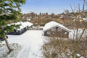 Et snæverkædet ejendom med flere bygninger, en synlig indkørsel og et omkringliggende landskab.