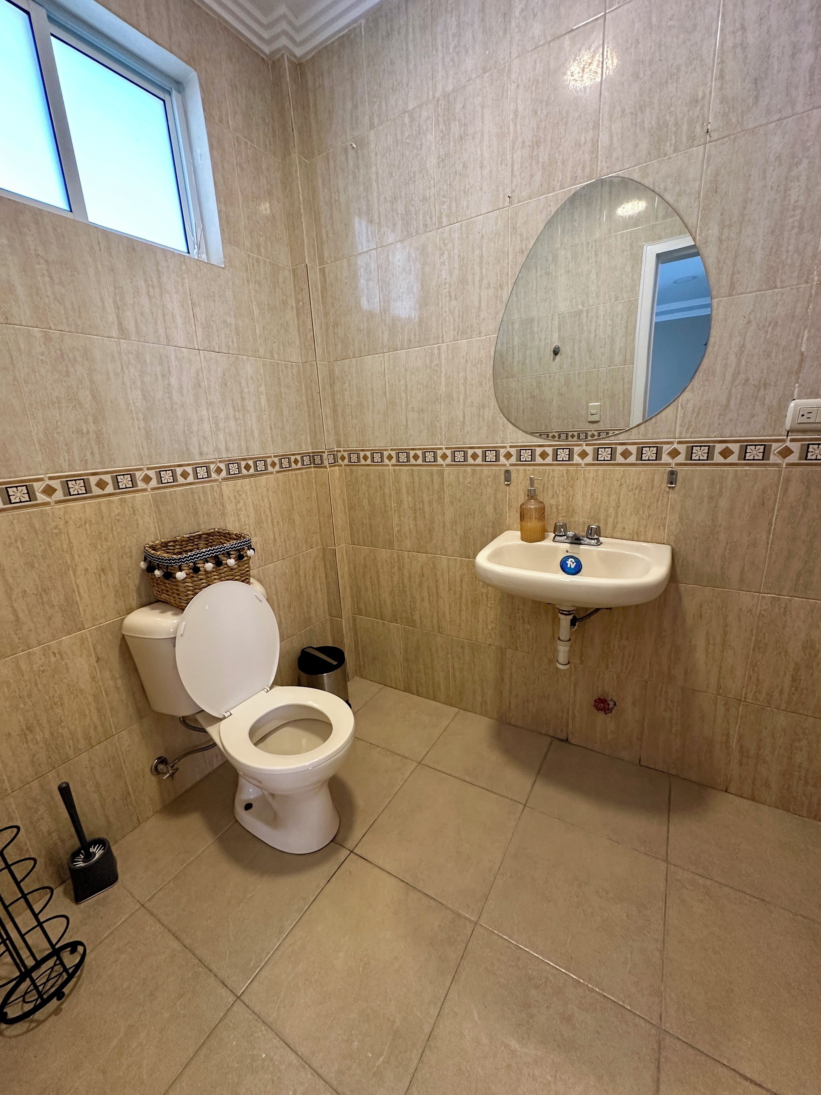 Ein Badezimmer mit Toilette, Waschbecken und Spiegel.