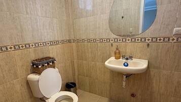 Ein Badezimmer mit Toilette, Waschbecken und Spiegel.