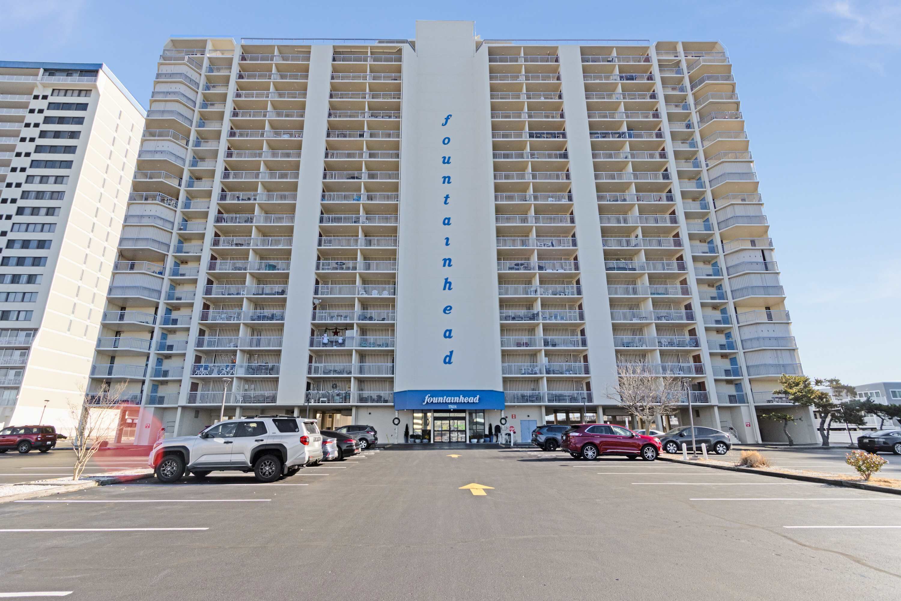 Un hotel de varios pisos con un llamativo letrero vertical que dice "fountainhead".
