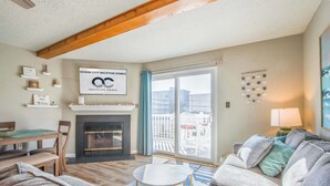 Ein geräumiges Wohnzimmer mit Kamin, Essbereich und einer großen Schiebeglastür zum Außenbereich.