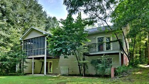 A two-story house with a large glass window on the first floor and a balcony on the second floor. - Tigers Den - Charming 4bd Lake Hartwell Lakefront house 11 miles to Clemson (Seneca)