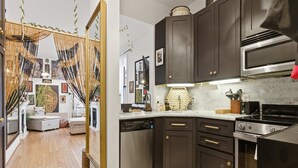 A modern kitchen with dark cabinets, stainless steel appliances, and a central island.
