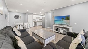 Ein modernes Wohnzimmer mit Sofa, Couchtisch und Fernseher.
