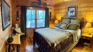 Une chambre confortable, aménagée dans le style d’un chalet, avec un lit en bois, un petit bureau et une chaise.