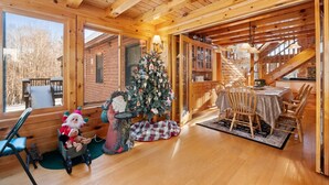 A cozy cabin interior with wooden walls, a dining area, and a Christmas tree. - Shepardson Brookside: VAST+AT Hike | A/C | Brook (Stratton)