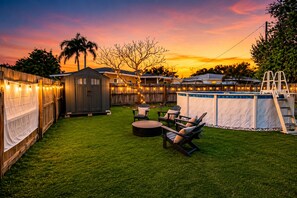 A backyard with a wooden deck, a shed, a pool with a ladder, and outdoor seating. - Poolside Playhouse - Pool Home - 5 Min. To Beach (Seminole)