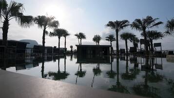 3 ulkouima-allasta, aurinkotuoleja