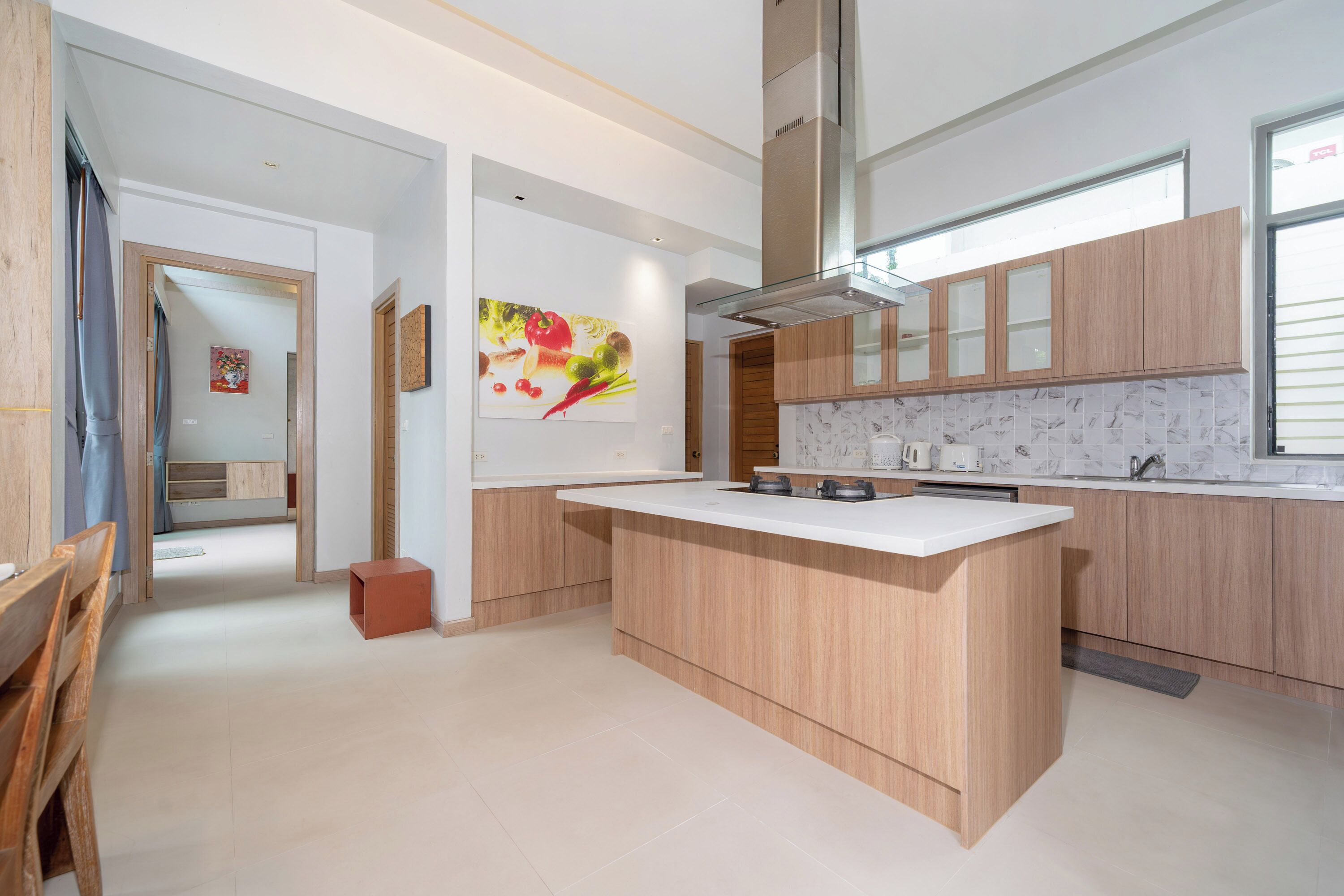 Een moderne keuken met houten kastjes, een centraal eiland en een betegelde achterwand.