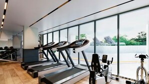 A modern gym with treadmills, a stationary bike, and a rowing machine. - Space Cherngtalay In Elegant Bangtao (Choeng Thale)