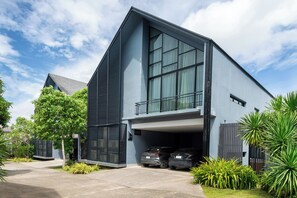 Uma casa moderna de dois andares com telhado inclinado, janelas amplas e garagem coberta.