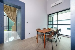 Uma sala de reuniões moderna com mesa e cadeiras de madeira, janelas amplas e vista para o exterior.